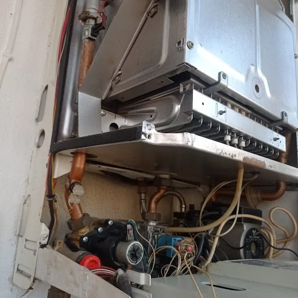 Açık kombi gövdesi içindeki boru ve vana tesisatının görünümü